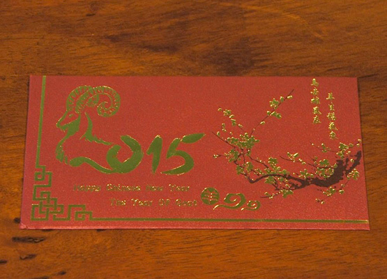 金箔で羊と梅の花が描かれた赤い封筒の写真
