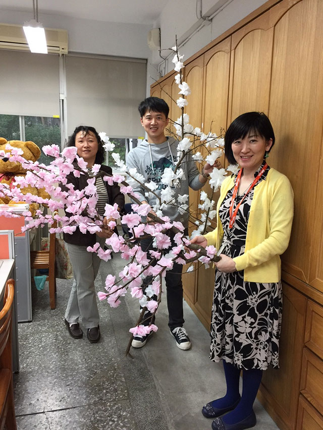 大きな桜の枝を持った斎藤さんと先生の写真
