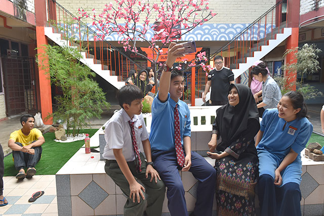 完成した日本風ガーデンの前で撮影しあう生徒たちの写真