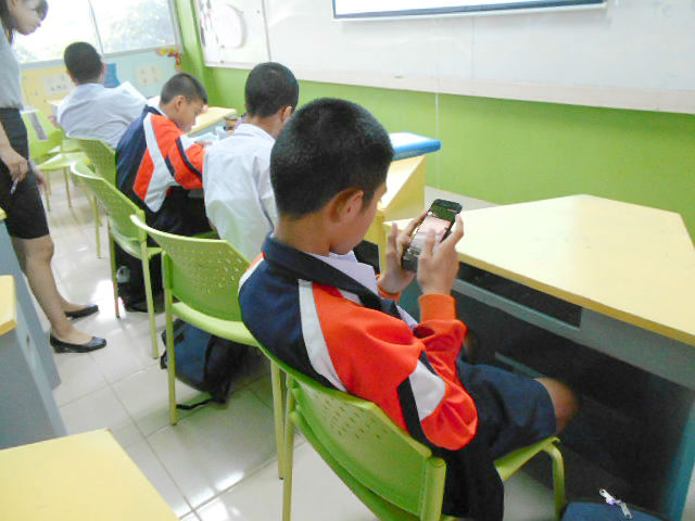 スマートフォンを操作する生徒の写真