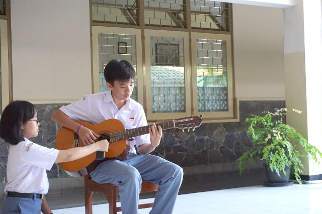 ギターで演奏する男子生徒の写真