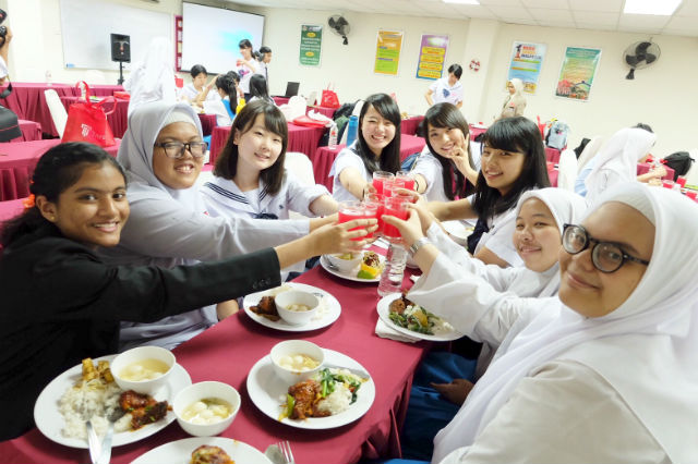日本とマレーシアの高校生たちが食事しながら交流している写真