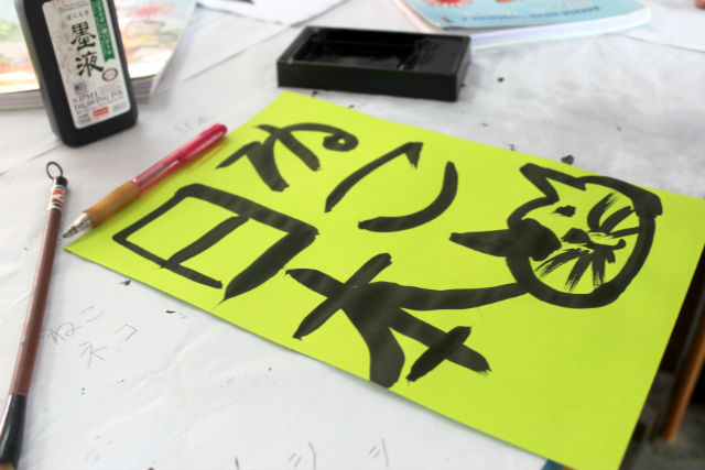 黄色い紙の書かれた「ねこ日本」の文字と猫のイラストの写真