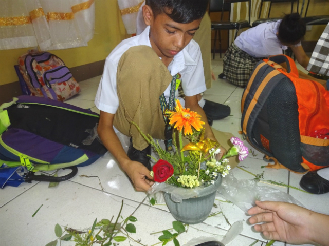 花をいける男子生徒の写真