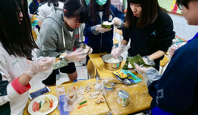 手巻き寿司づくりに挑戦する生徒たちの写真