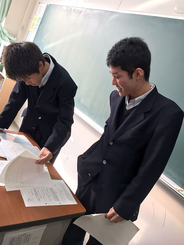手紙を見てはにかみながら嬉しそうな日本の高校生の写真