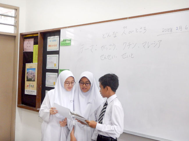 日本語パートナーズ マレーシア サラワク州 日本語の形容詞を使ったマレーシアとクチンなどのPRについて相談する生徒たち