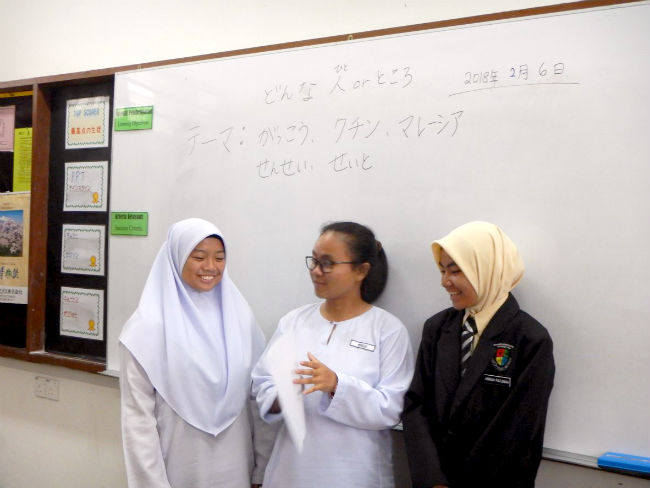 日本語パートナーズ マレーシア サラワク州日本語の形容詞を使ったマレーシアとクチンなどのPRについて相談する生徒たち