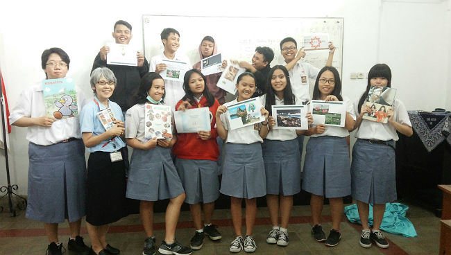 日本語パートナーズ インドネシア ジョグジャカルタ 生徒たちが調べた埼玉県の好きな場所の紹介資料を手にして
