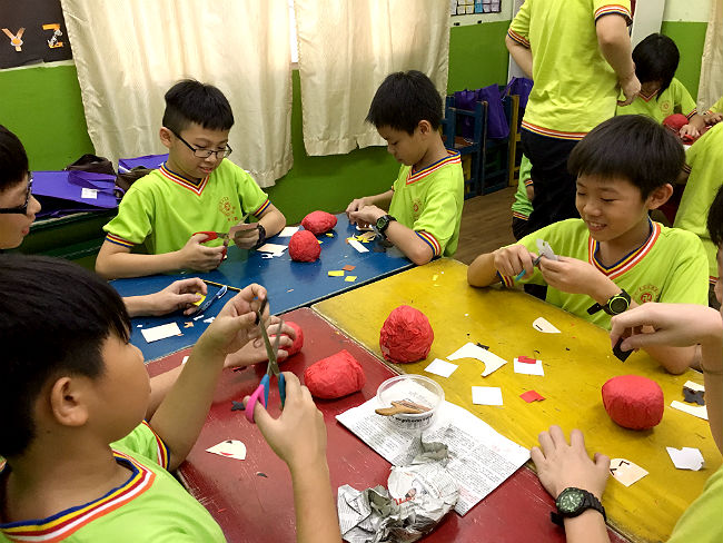 日本語パートナーズ マレーシア ジョホール州 お寺の小学生たちもだるま作りを体験する様子