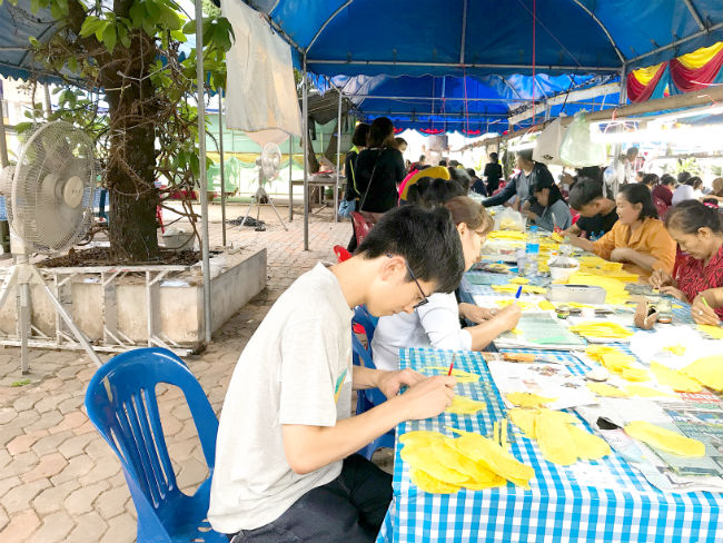 タイ、ウボンラーチャターニーの日本語パートナーズの活動 ウボン名物の「ろうそく祭り」に参加した写真5 削りだす作業のお手伝いをしている加藤さんの写真