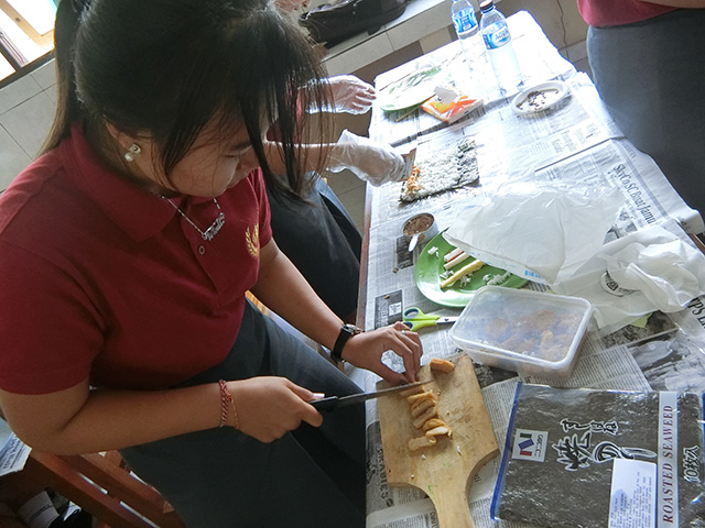 ナゲット巻き寿司を作る生徒の写真