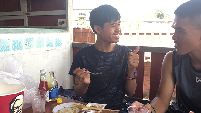 ハチミツをかけた納豆を食べて笑顔の生徒の写真