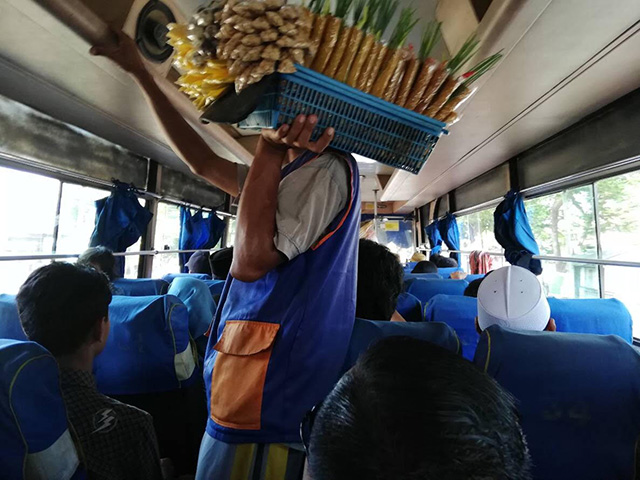 バスの車内で食べ物を売っている様子の写真
