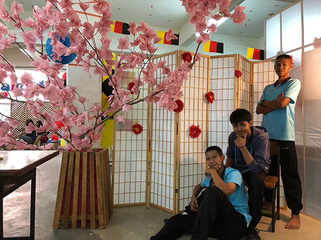 日本風フォトブースでポーズをきめる男子生徒三人の写真