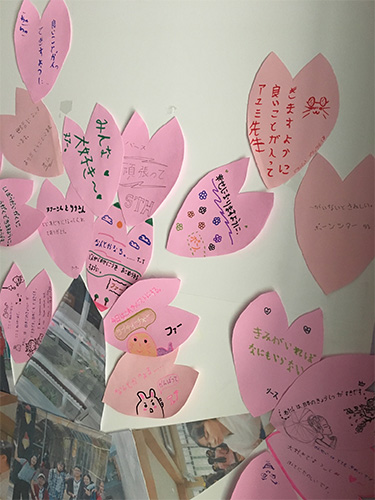 桜の花びら一枚一枚に日本語で書かれた願い事の写真