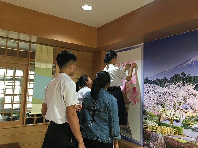 桜を飾りを掲示する生徒の写真