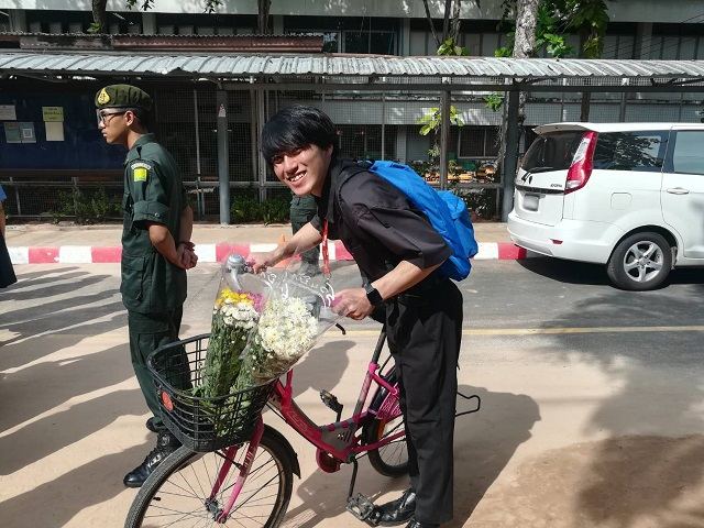 購入した花を自転車のカゴに入れて登校する日本語パートナーズの写真