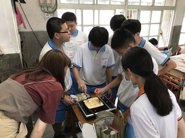 たこ焼きを作る生徒と日本語パートナーズの写真 1