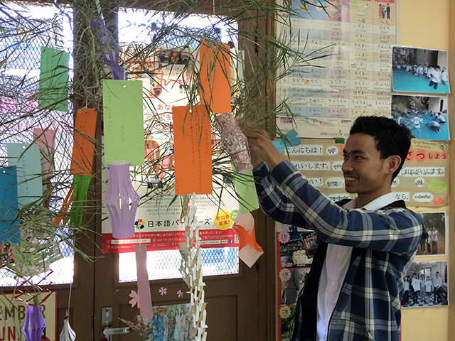 笹の枝に飾りつけをする生徒の写真