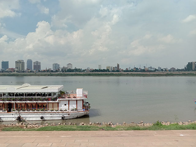 観光船とビル群も見える川辺の写真