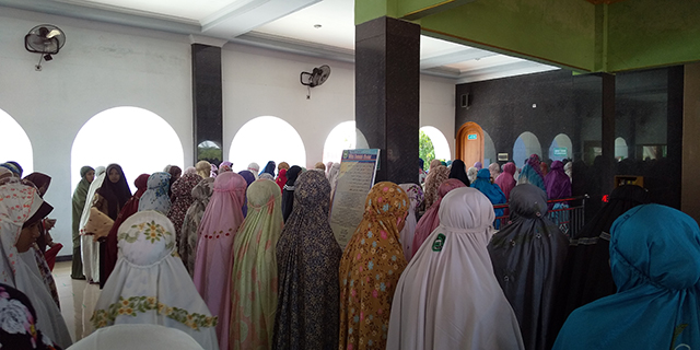 様々なデザインのムクナを着用した生徒たちが集まるモスクの写真