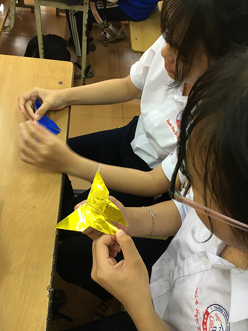 折り紙に挑戦する女子生徒の写真