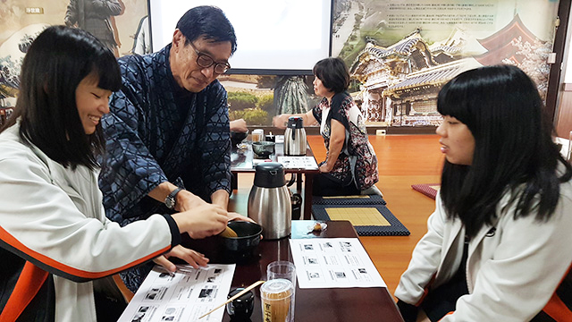 山崎さんが生徒に茶道を教えている様子の写真
