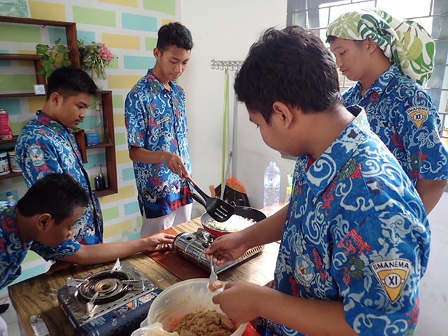 料理に挑戦する男子生徒たちの写真