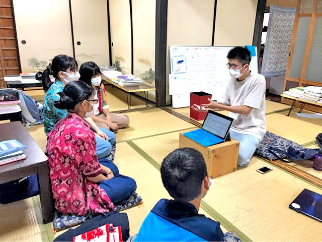 座敷でバティックを着た日本の子供たちと、インドネシアの話をする瀬戸さんの写真