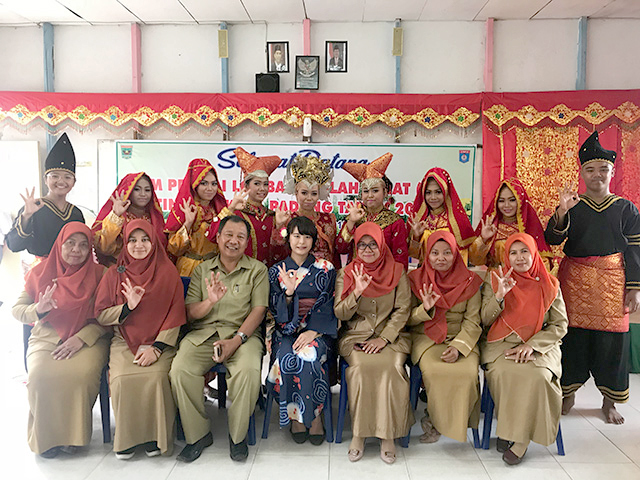 歓迎の儀式の伝統衣装を着た女性や先生がたと撮影した集合写真