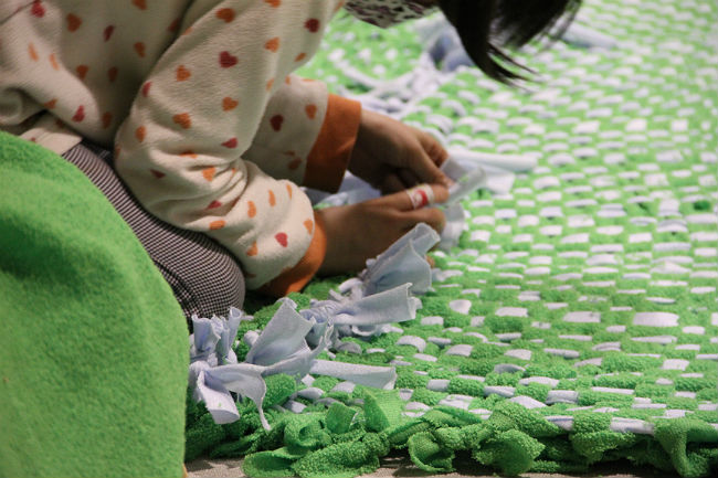プロジェクト『マイタウンマーケット』で行われた絨毯を編んでいる写真