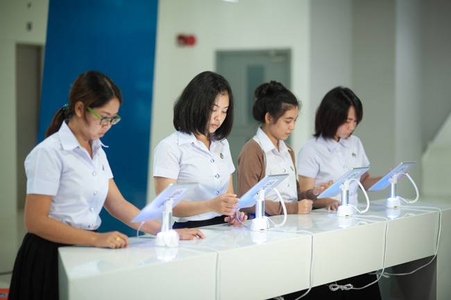 A photo of girls reading books on tablets