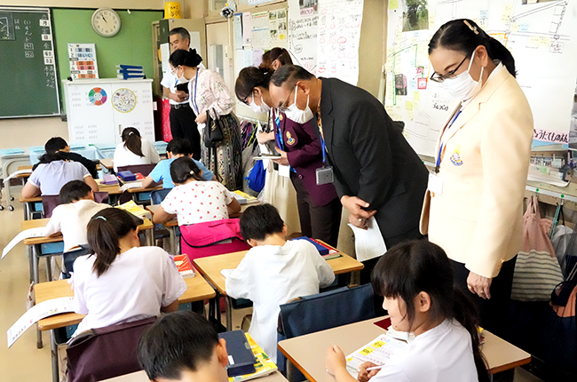 教室で授業を受ける子供たちの横でそれを視察している様子
