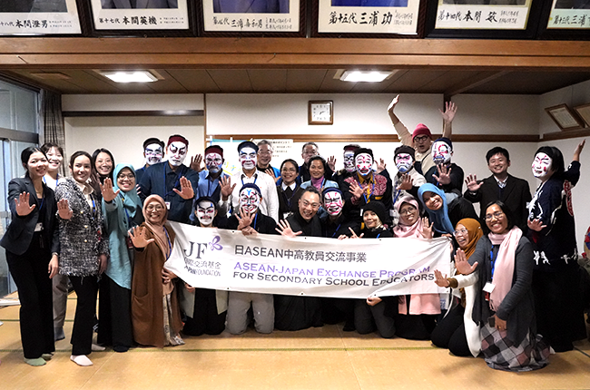 顔に隈取をしたり大見得のポーズをして畳の室内で集合写真、