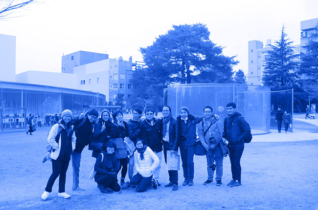 約12人が並んで記念撮影をしている青い色調の写真