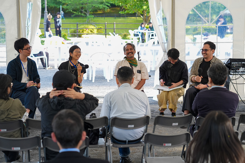 The photo shows the three people who took the stage at the talk event, the moderator, and the translator.