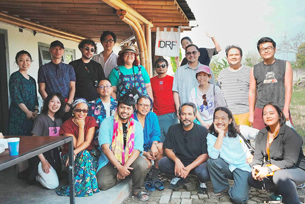 A group photo of 19 people facing the camera outdoors in Yogyakarta.