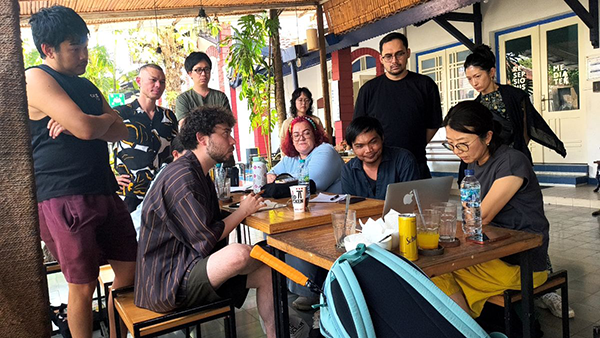 In a semi-outdoor spot, ten people are gathered around a table.