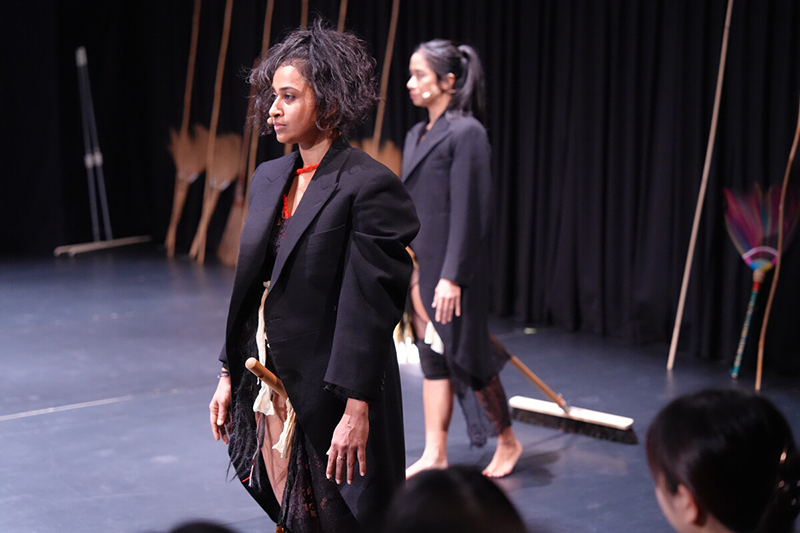 There are two women wearing jackets on the stage.